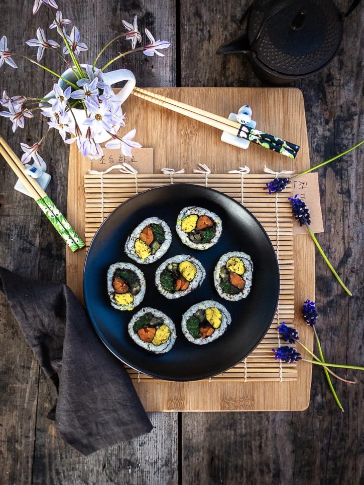 Kimbap coréen vegan sur planche avec tapis de bambou