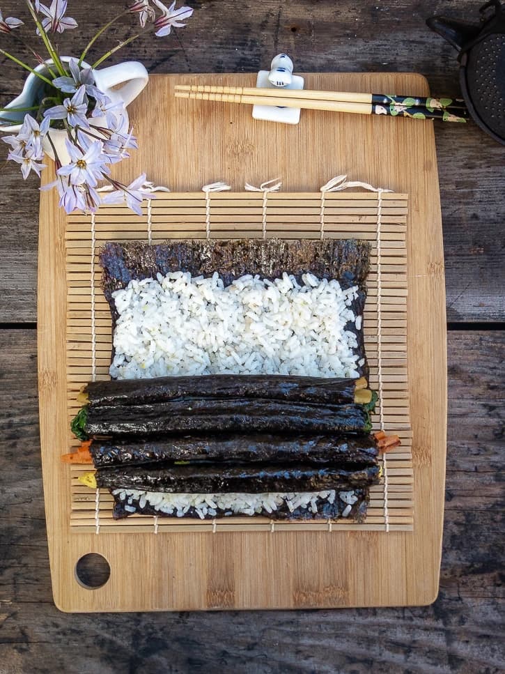 Kimbap coréen vegan sur planche avec tapis de bambou
