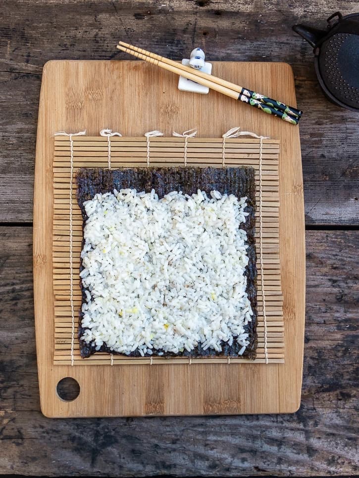 Planche avec tapis de bambou, feuille de nori et riz