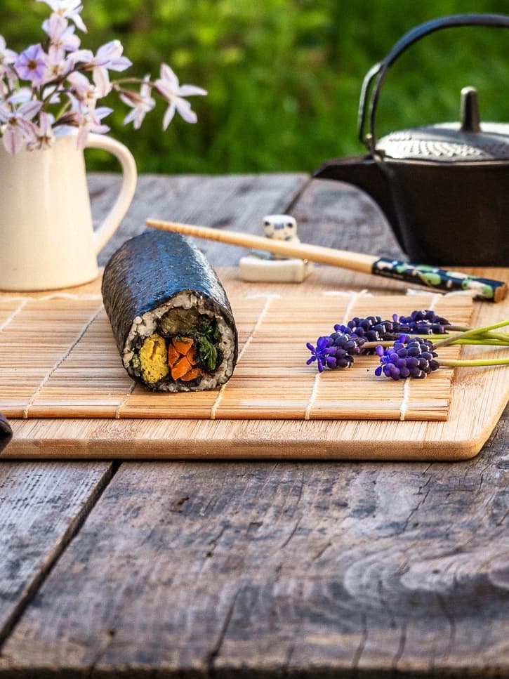 Rouleau de kimbap coréen vegan dans un décor de jardin