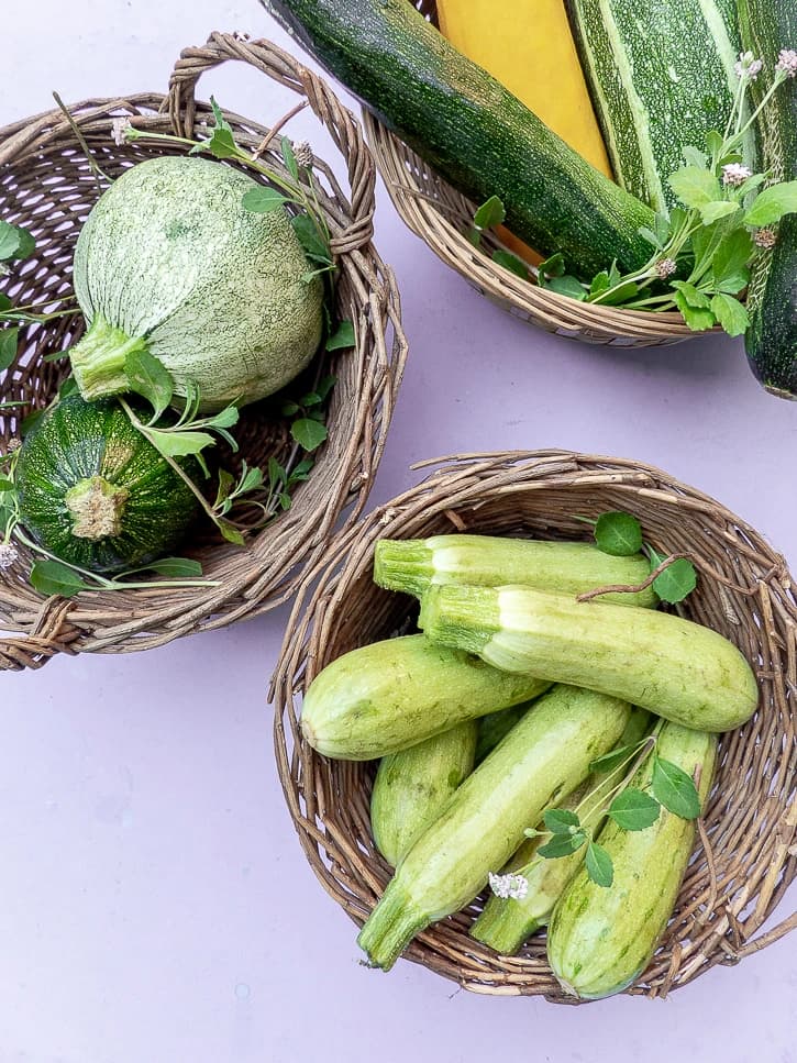 Différentes couleurs et variétés de courgettes présentées dans un panier
